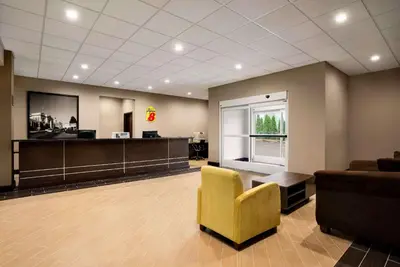 a waiting room with a yellow chair and a couch at Super 8 by Wyndham Hershey Chocolate Avenue in Hershey