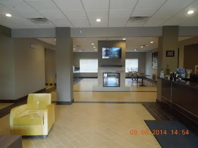 a lobby with a fireplace and a tv on the wall at Super 8 by Wyndham Hershey Chocolate Avenue in Hershey