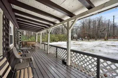 a porch with benches and a snow covered yard at Log Cabin and Guest House Sleeps 18 2 Game Rooms in Long Pond