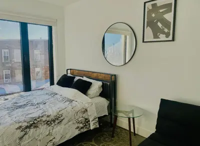 a bedroom with a bed and a mirror and a window at Cozy apt with great city view in Union City