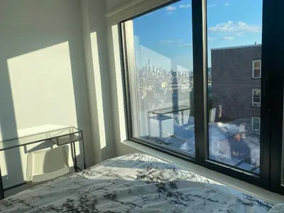 a bedroom with a large window with a view of the city at Cozy apt with great city view in Union City