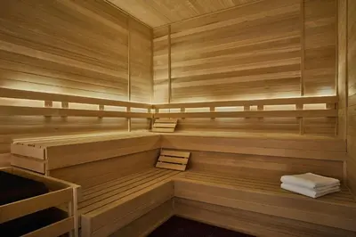 a sauna with wooden walls and benches and towels at Pendry Natirar in Peapack