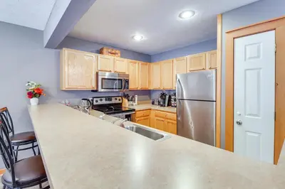 a kitchen with wooden cabinets and a stainless steel refrigerator at Cozy Cove Near Waterparks, Zip Line, Ski and More in Tannersville