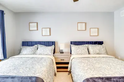 a bedroom with two beds and a nightstand between them at Cozy Cove Near Waterparks, Zip Line, Ski and More in Tannersville