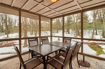 a screened in porch with a table and chairs at Cozy Cove Near Waterparks, Zip Line, Ski and More in Tannersville