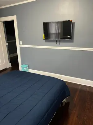 a bedroom with a bed and a flat screen tv on the wall at Two Bedrooms Home in Irvington