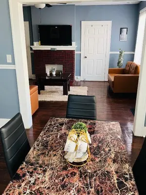 a living room with a table and chairs and a television at Two Bedrooms Home in Irvington