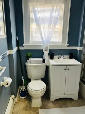a bathroom with a toilet and a sink and a window at Two Bedrooms Home in Irvington