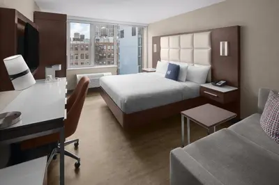 a hotel room with a bed and a desk at Cambria Hotel New York - Chelsea in New York