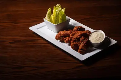 a plate of food with lettuce and dip on a table at Cambria Hotel New York - Chelsea in New York