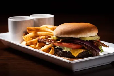 a plate with a sandwich and french fries on a table at Cambria Hotel New York - Chelsea in New York