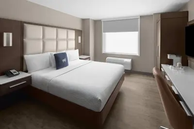 a hotel room with a large bed and a television at Cambria Hotel New York - Chelsea in New York