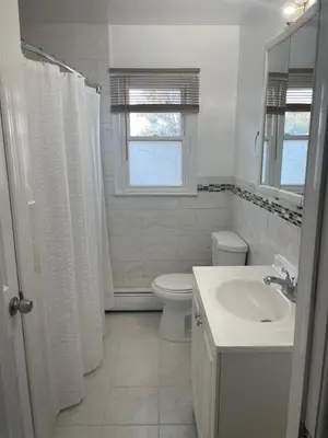 a white bathroom with a sink and a toilet at Cozy Home Near Downtown Rahway in Rahway