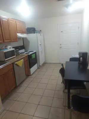 a kitchen with a refrigerator and a table in it at Deluxe Room A 12 minutes to Ewr in Newark
