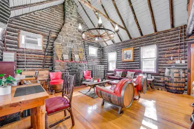 a room with a stone wall and tables and chairs at Easy Interstate Access Original Poconos Log Cabin in Blakeslee