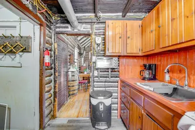 a kitchen with wooden cabinets and a sink and a counter at Easy Interstate Access Original Poconos Log Cabin in Blakeslee
