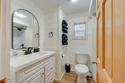 a bathroom with a toilet and a sink and a mirror at 4 Mi to Big Boulder The Cozy Cabin on 8 Acres! in Blakeslee