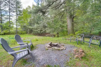 a fire pit with two chairs and a campfire at 4 Mi to Big Boulder The Cozy Cabin on 8 Acres! in Blakeslee