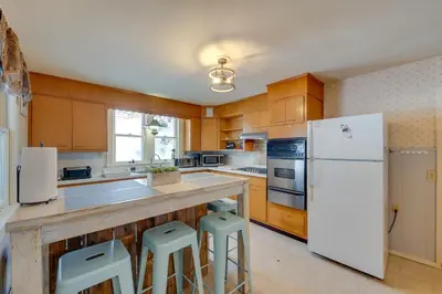 a kitchen with a white refrigerator and two stools at Private Hot Tub Poconos Babbling Brooke Cottage in Blakeslee