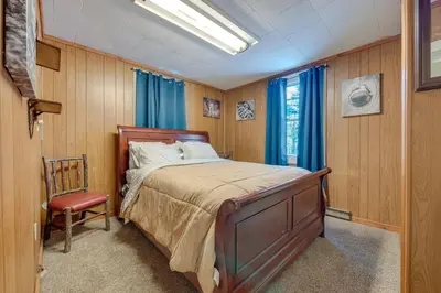 a bedroom with a bed and a chair in it at Private Hot Tub Poconos Babbling Brooke Cottage in Blakeslee