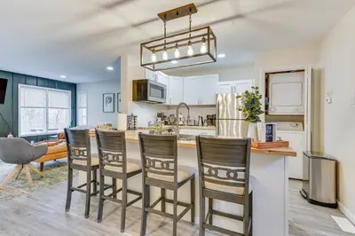 a kitchen with a bar with chairs and a table at East Stroudsburg Townhouse Less Than 1 Mi to Ski Area! in East Stroudsburg