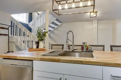 a kitchen with a sink and a staircase at East Stroudsburg Townhouse Less Than 1 Mi to Ski Area! in East Stroudsburg