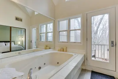 a large white bathroom with a large tub and a bed at East Stroudsburg Townhouse Less Than 1 Mi to Ski Area! in East Stroudsburg