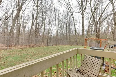 a balcony with a chair and a fence and trees at East Stroudsburg Townhouse Less Than 1 Mi to Ski Area! in East Stroudsburg