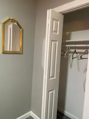 a bathroom with a white door and a mirror at Cozy Getaway Room in Newark