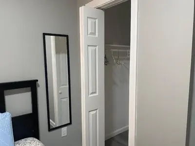 a white door with a mirror next to a closet at Cozy Getaway Room in Newark