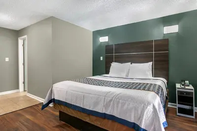 a bedroom with a large bed with green walls at Knights Inn Bristol in Levittown