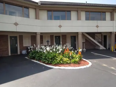 a building with a flower bed in front of it at Knights Inn Bristol in Levittown