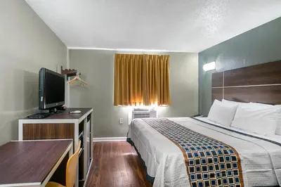 a hotel room with a bed and a flat screen tv at Knights Inn Bristol in Levittown