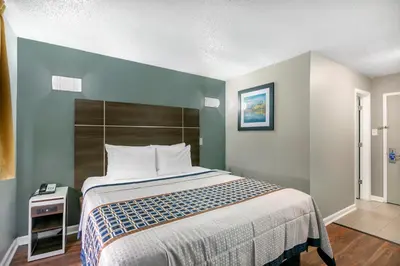a bedroom with a large bed with a blue wall at Knights Inn Bristol in Levittown
