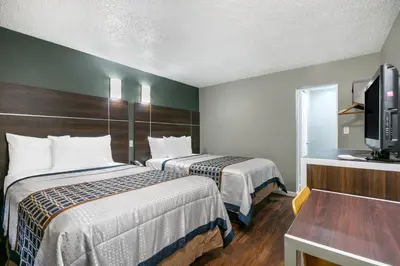 a hotel room with two beds and a flat screen tv at Knights Inn Bristol in Levittown