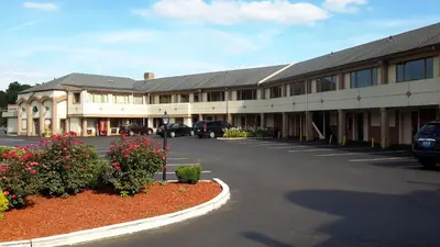 a large building with cars parked in a parking lot at Knights Inn Bristol in Levittown