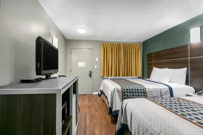 a hotel room with two beds and a flat screen tv at Knights Inn Bristol in Levittown