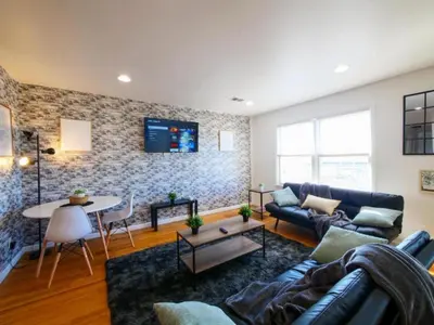a living room with a couch and a table at Cozy 3 - Bed apartment, Minutes from NYC! in Jersey City