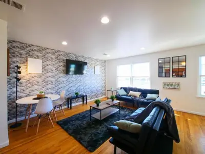 a living room with a couch and a table at Cozy 3 - Bed apartment, Minutes from NYC! in Jersey City