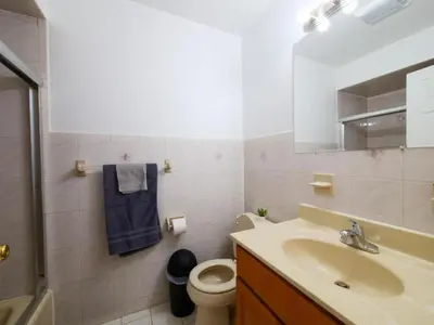 a bathroom with a sink and a toilet and a mirror at Cozy 3 - Bed apartment, Minutes from NYC! in Jersey City