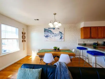 a living room with a table and chairs and a kitchen at Cozy 3 - Bed apartment, Minutes from NYC! in Jersey City