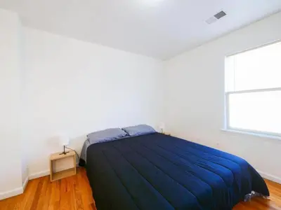 a bedroom with a bed and a large window at Cozy 3 - Bed apartment, Minutes from NYC! in Jersey City