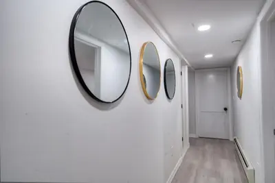 a hallway with three mirrors on a wall at Brand New House with Huge Patio in Kerhonkson