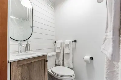 a bathroom with a toilet and a sink and a mirror at Overlook Brandywine Valley in Thornton