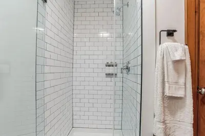 a bathroom with a glass shower with white tiles at Overlook Brandywine Valley in Thornton