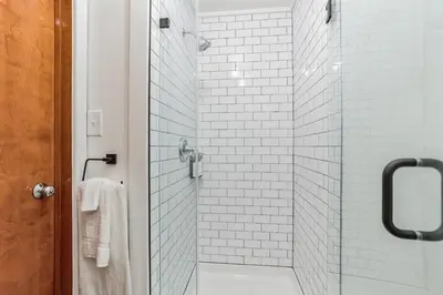 a bathroom with a glass shower with white tiles at Cozy retreat in Thornton PA in Thornton