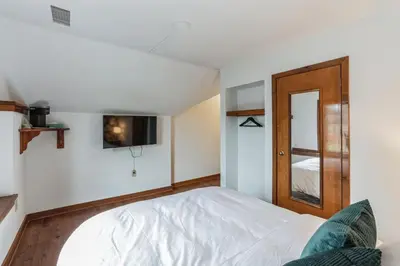 a bedroom with a white bed and a wooden door at Cozy retreat in Thornton PA in Thornton