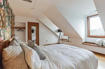 a bedroom with a white bed in a attic at Charming Studio in Thornton PA in Thornton