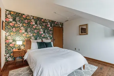a bedroom with a large bed with a floral wallpaper at Charming Studio in Thornton PA in Thornton