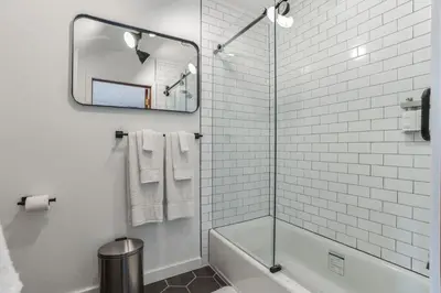 a bathroom with a tub and a shower with a mirror at Charming Studio in Thornton PA in Thornton